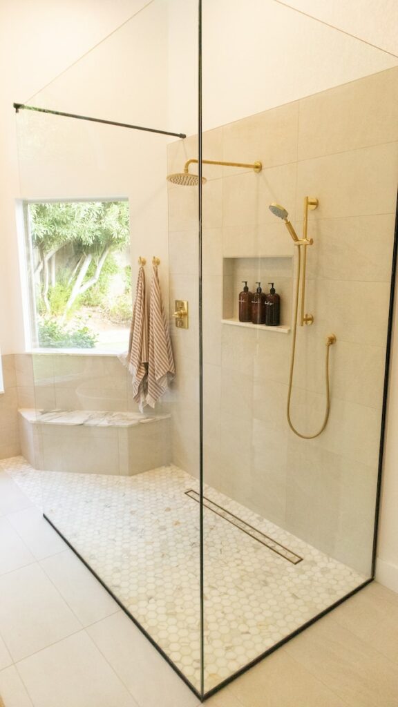 Un baño blanco y clásico con accesorios dorados